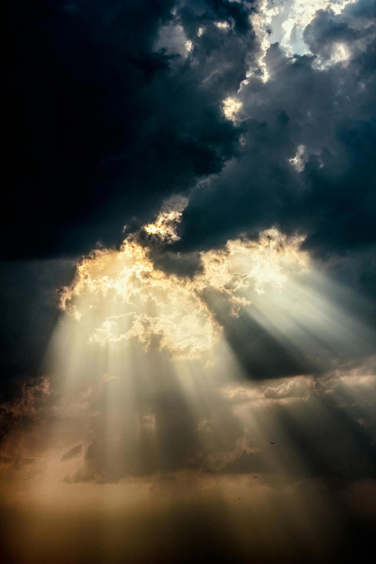 sunlight filtering through dark clouds